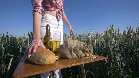 一个农民女孩的手紧紧地在麦田里倒了一把麦粒视频的预览图
