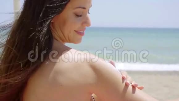 年轻女子在肩膀上涂防晒霜视频的预览图