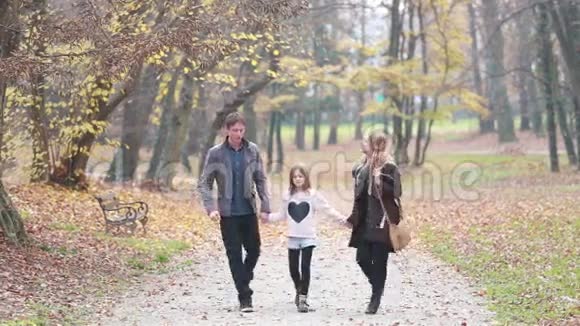幸福的家庭牵手在公园散步视频的预览图