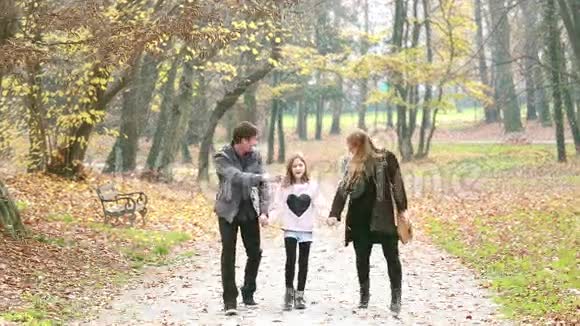 幸福的家庭牵手在公园散步视频的预览图