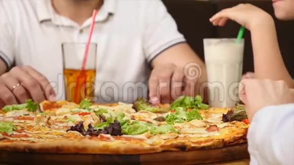 手从桌上的盘子里拿披萨一群饥饿的人和食物视频的预览图