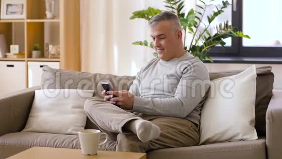 有智能手机的男人在家喝咖啡视频的预览图
