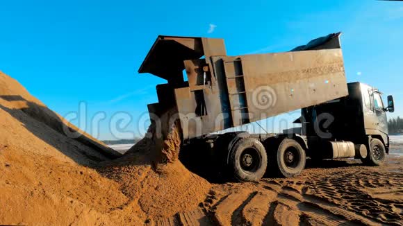自卸汽车在施工现场卸土大型三轴翻斗车在采石场或露天采场倒出沙子视频的预览图