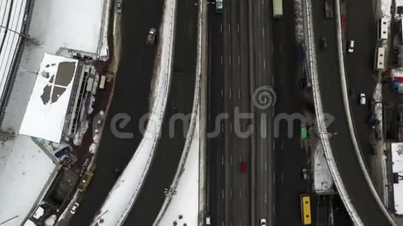 城市冬季道路上的俯视车冬季城市道路交叉口高空作业视频的预览图