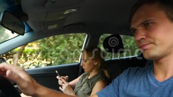 一个女人在司机旁边的车里开车正在打电话4k慢镜头视频的预览图