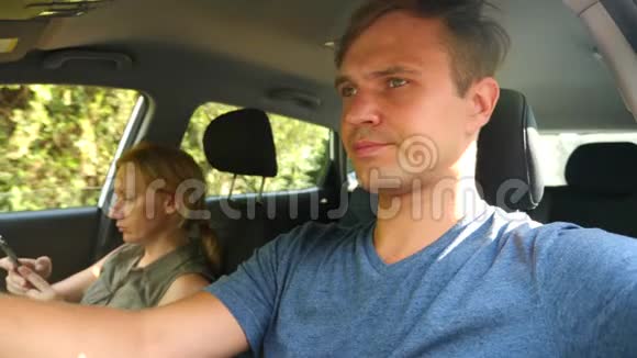 一个女人在司机旁边的车里开车正在打电话4k慢镜头视频的预览图
