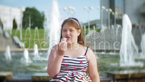 孩子小女孩在炎热的夏天吃冰淇淋孩子们在喷泉附近视频的预览图