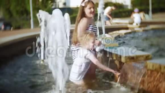 儿童小女孩在炎热炎热的夏日吃冰淇淋孩子们在喷泉附近视频的预览图