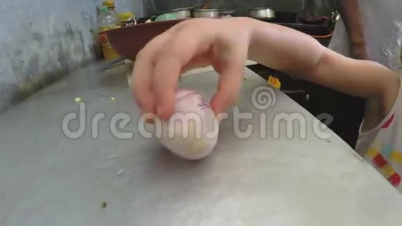 小白种人金发女孩在厨房里玩洋葱的慢动作视频的预览图