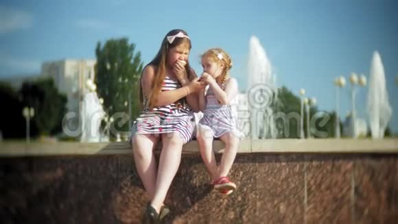 孩子小女孩在炎热的夏天吃冰淇淋孩子们在喷泉附近视频的预览图