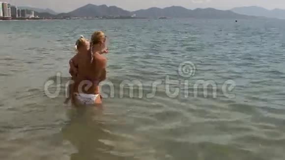 小妈妈抱着小女儿在浅水里视频的预览图