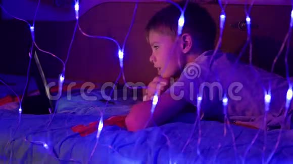 孩子看着躺在床上的药片前景上灯光花环视频的预览图