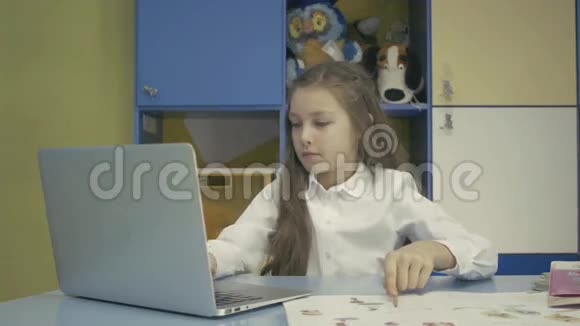 小女孩在学校用笔记本电脑做作业视频的预览图