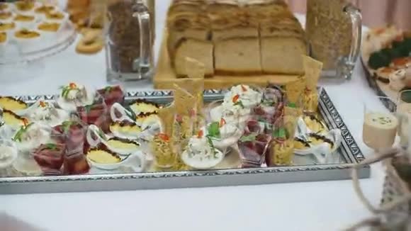 精美装饰的宴会桌上有不同的食品小吃和企业圣诞节生日开胃菜视频的预览图