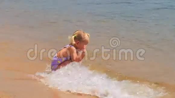 小女孩带着裙子从沙滩上的波浪中奔跑视频的预览图