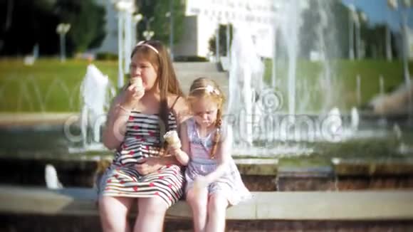 儿童小女孩在炎热炎热的夏日吃冰淇淋孩子们在喷泉附近视频的预览图