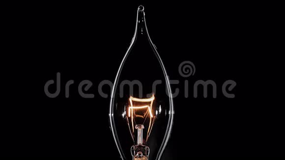 蜡烛形状的爱迪生灯闪过黑色的宏观视野视频的预览图
