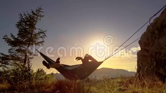 日落时分在吊床上放松的人视频的预览图