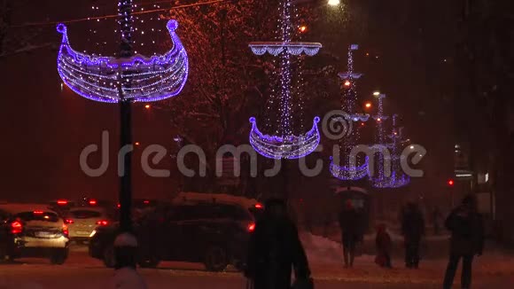 白雪皑皑的黄昏街道上行人在圣诞节的光照下大雪纷飞视频的预览图