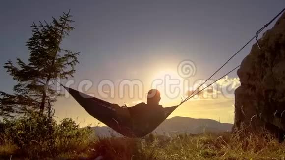 日落时分在吊床上放松的人视频的预览图