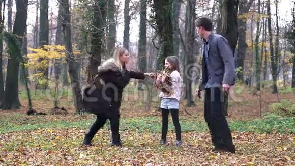 一家人一起玩在公园里互相扔树叶视频的预览图