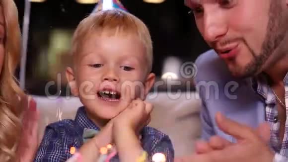 小男孩在生日蛋糕上吹蜡烛视频的预览图