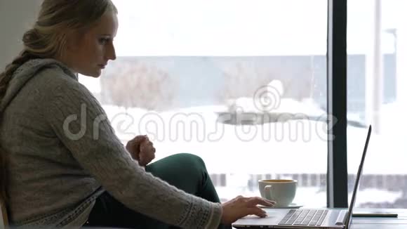 在咖啡馆里用笔记本电脑工作的年轻女子视频的预览图
