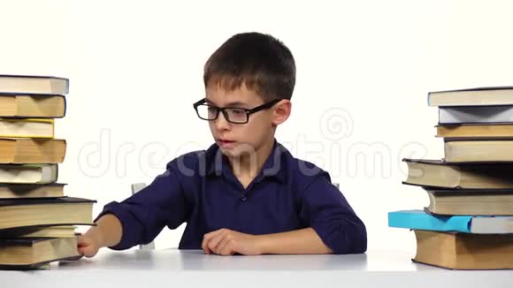 男孩坐在桌子旁看书白色背景视频的预览图