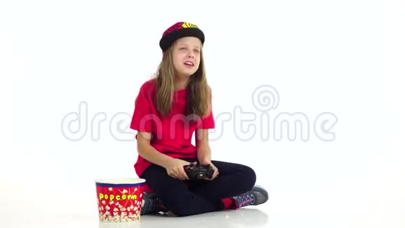 青少年在网络游戏中玩操纵杆吃爆米花慢动作视频的预览图