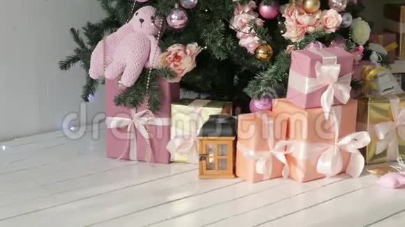 圣诞礼物立在树下粉红色和橙色的盒子有浅色丝带视频的预览图