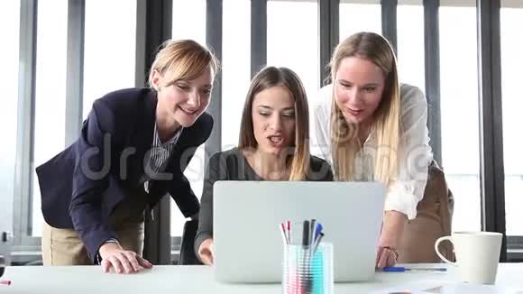 三个快乐的女商人带着笔记本电脑兴高采烈视频的预览图