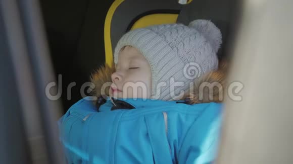 幼儿男孩在汽车上睡在儿童安全座椅上视频的预览图