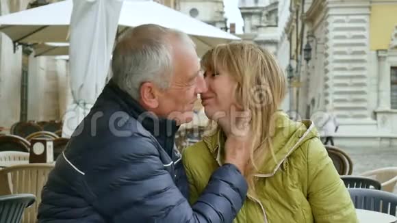 一位英俊的老人正拥抱着他年轻的金发妻子在古城里度过了一段时间视频的预览图