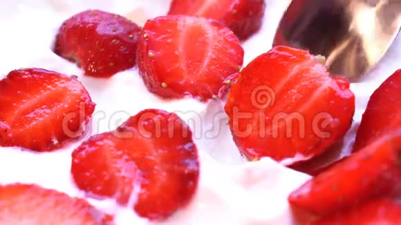 草莓是用勺子从奶油中取出的一次宏观射击视频的预览图