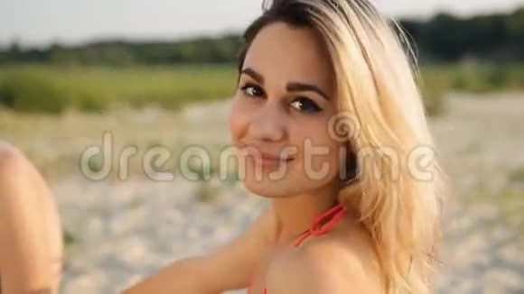炎炎夏日沙滩上金发女郎的肖像视频的预览图