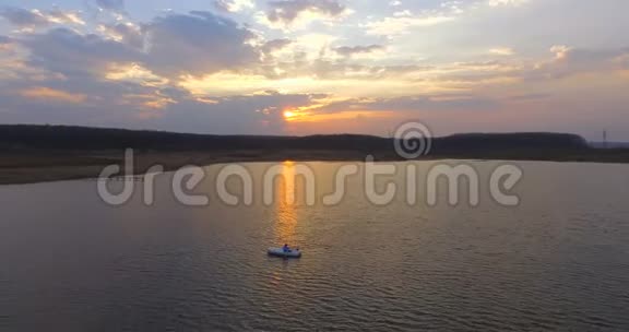 鸟瞰在白船男子骑在湖上日落豪华度假视频的预览图
