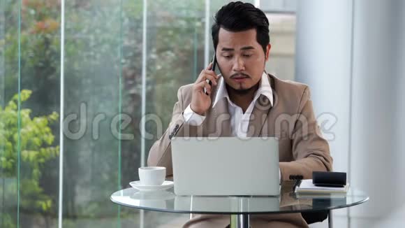 商务人士用手机和笔记本电脑说话视频的预览图