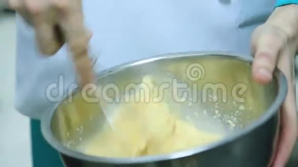 男性手在金属搅拌碗中搅拌面糊视频的预览图