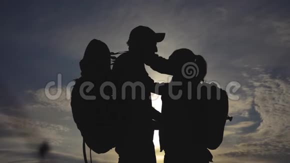 幸福的家庭游客剪影在日落拥抱接吻团队合作旅游概念男人和女人的生活方式视频的预览图