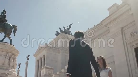 在意大利罗马的阿尔塔雷德拉帕特拉面前摆姿势的婚礼情侣时髦的新郎围着美丽的新娘走视频的预览图