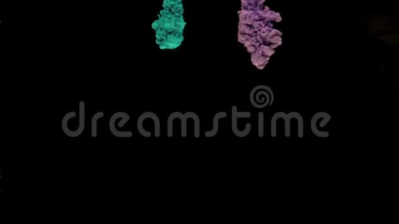 五颜六色的绿松石和紫罗兰色墨水滴在水面上混合在黑色背景下轻轻旋转复制空间视频的预览图