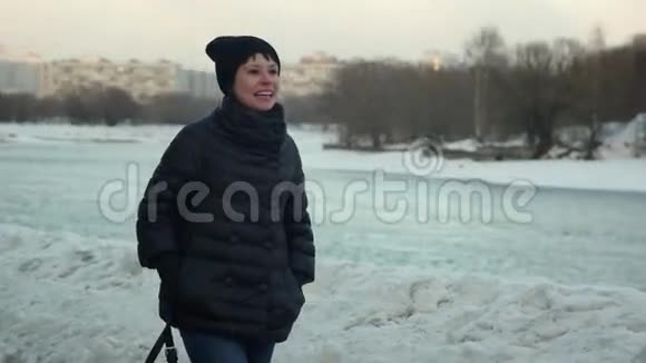 一个快乐的女孩正在冬天的公园里散步慢动作视频的预览图