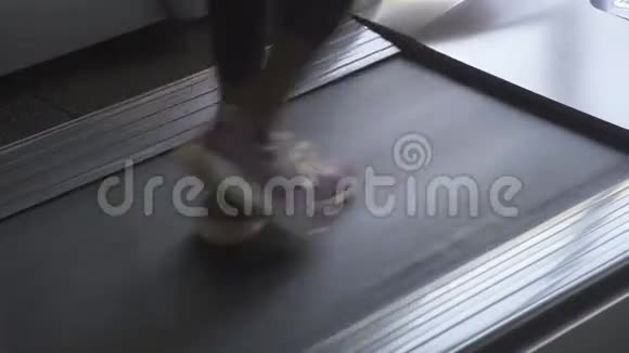用紫色运动鞋在跑步机上行走把女人的腿收起来侧视视频的预览图