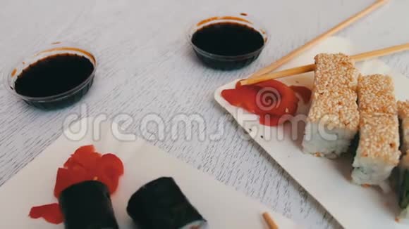 日本料理寿司有三文鱼粉姜青芥末和白色盘子上的酱油视频的预览图
