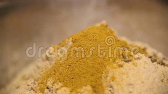 用香料用孜然和姜黄在一座面粉山上酿造视频的预览图