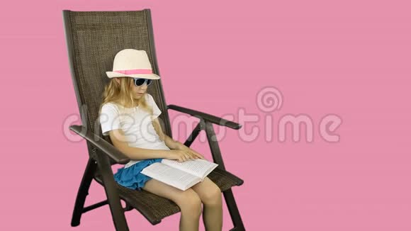 一个年轻女孩坐在椅子上看书视频的预览图