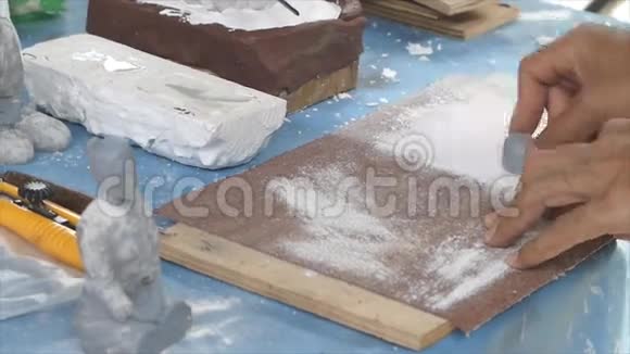 艺术家在砂纸上摩擦女性图形树脂的一部分视频的预览图
