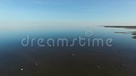 4K日落时分带着石头飞过大海站在水里和家人一起度假鸟瞰视频的预览图