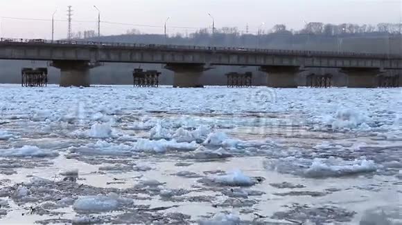 春休浮漂冰在河的背景下桥景从岸上看视频的预览图