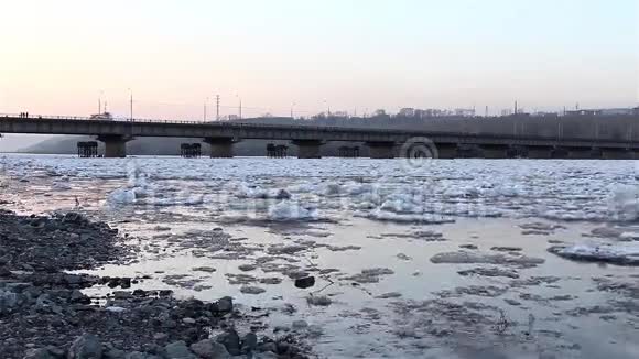 春休浮漂冰在河的背景下桥景从岸上看视频的预览图